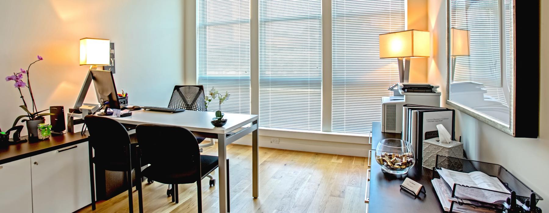 a room with a desk and chairs